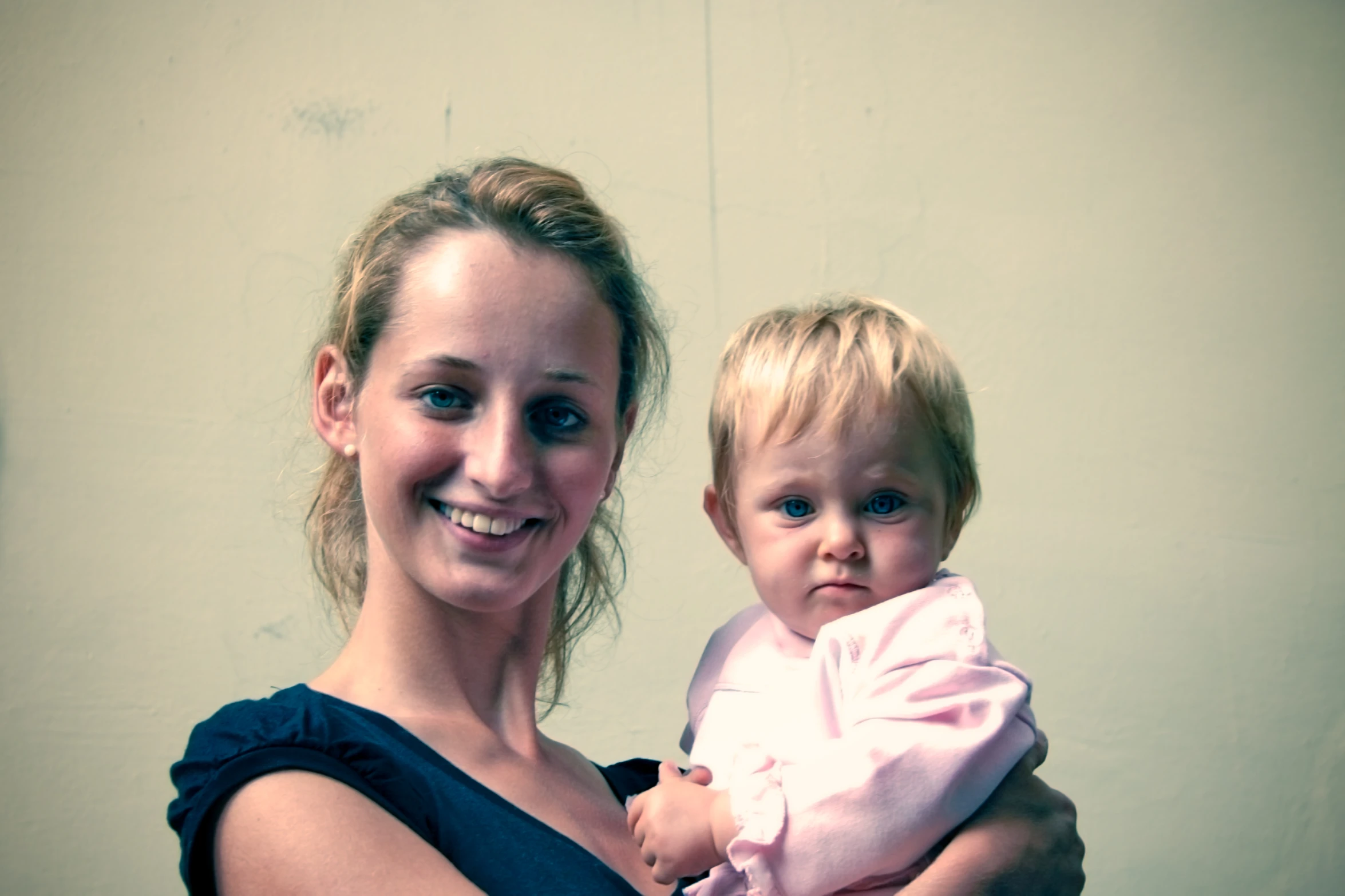 a woman smiles as she holds a young child