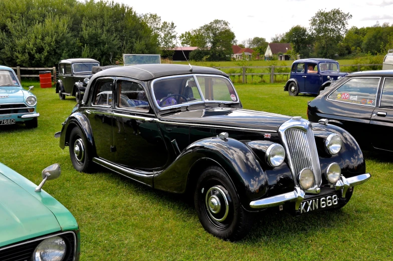 an old model car on the grass of a show