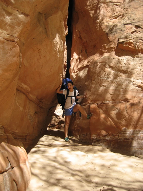 a person with a backpack climbing up a rock