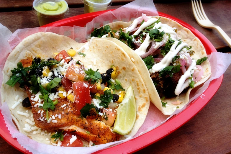 two fish tacos are on a pink plate