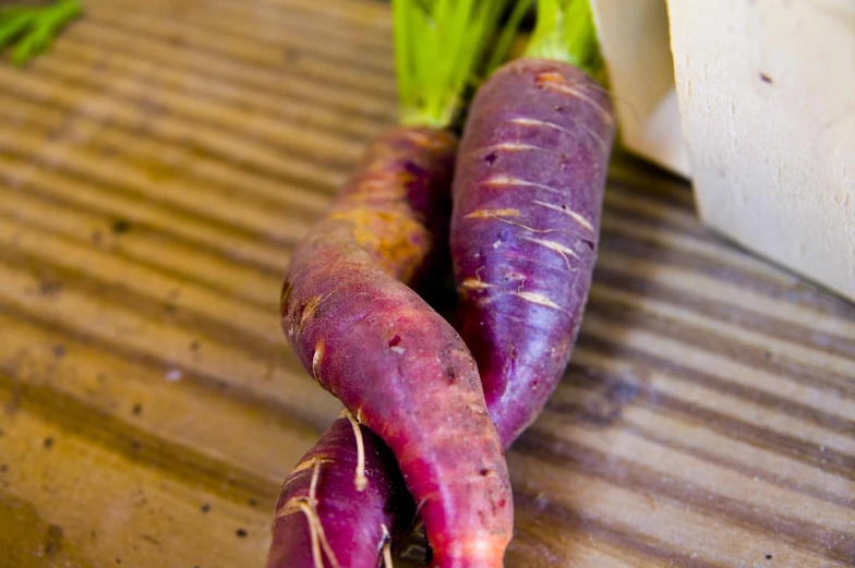 a close up of two small carrots on a wooden counter