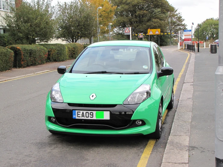 a bright green car sitting on the side of a street