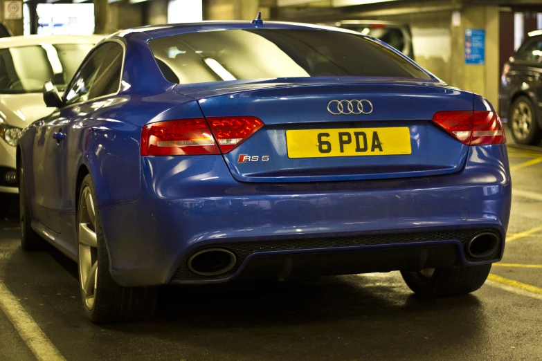 a blue audi is parked in a parking garage