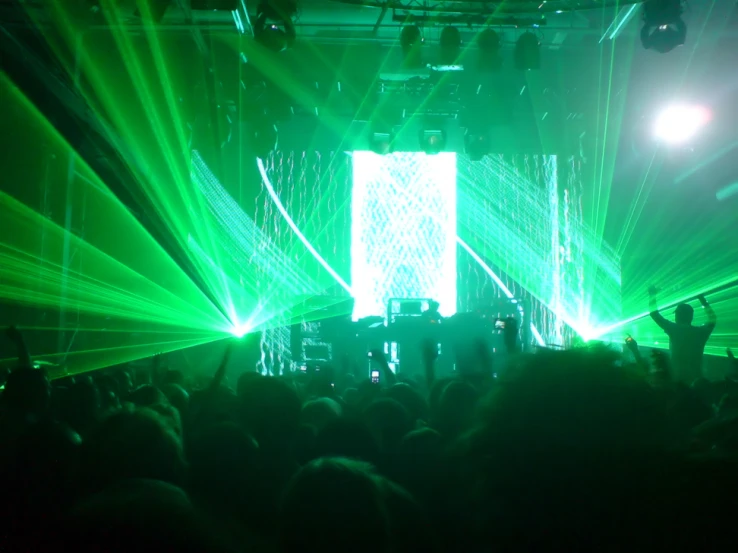 laser lights illuminate a stage with several persons