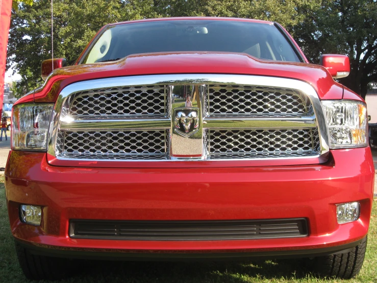 a red truck parked on the grass with trees in the background