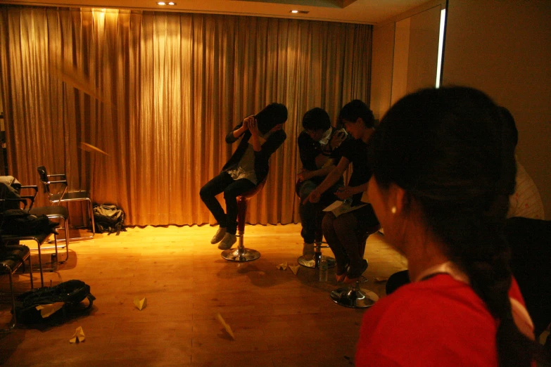 five women in a dimly lit room, two sitting