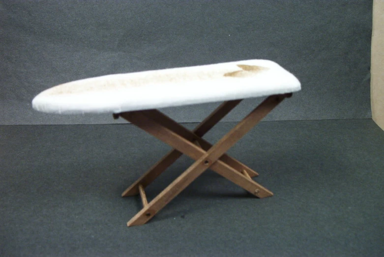 an open waxing ironing board with white fluffy cover on it