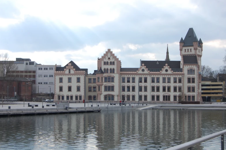 a castle type building next to water with a dock in front