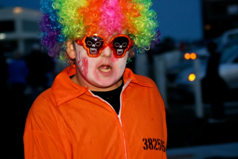 the little boy is wearing a clown wig and skulls in shades