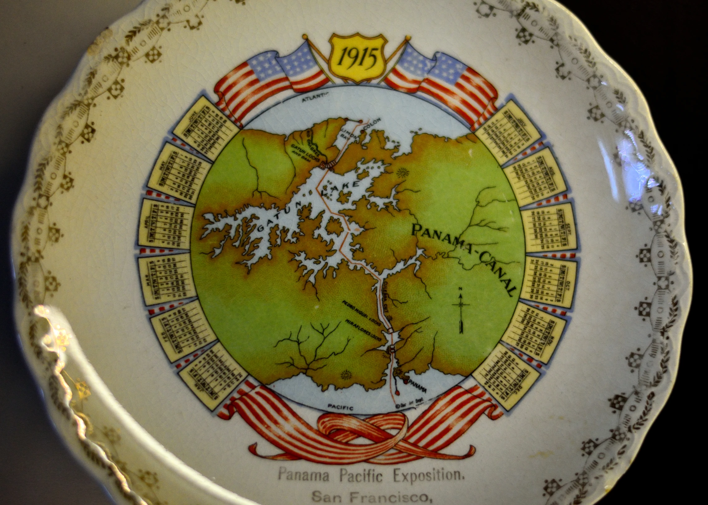 a close up image of a plate with a flag, map, and motto