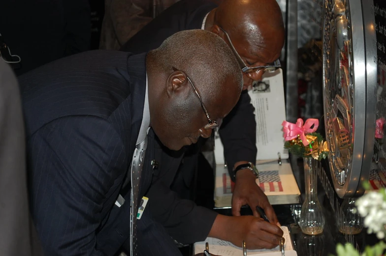 a man is signing a book at a ceremony