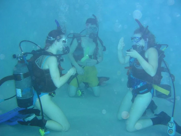 three people in swim suits are sitting in the water