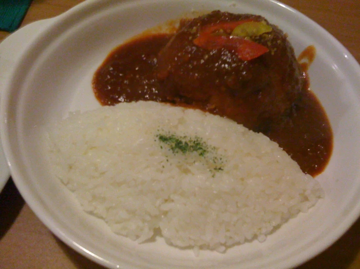 a plate with rice, a red chili and beans