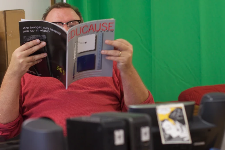 man reading an item in the newspaper while sitting in his chair