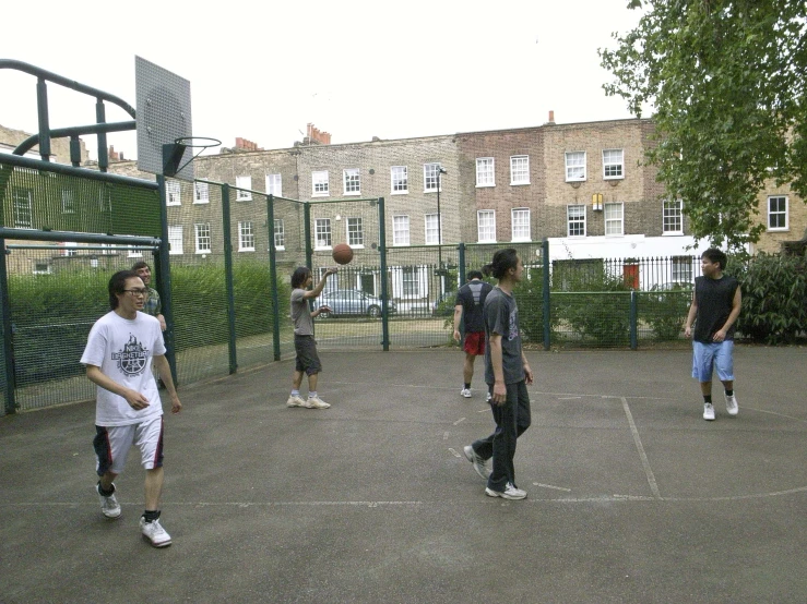 several s and young adults are playing basketball