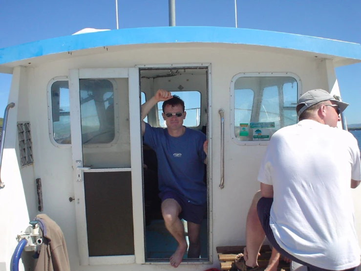 two people standing on the front of a small boat