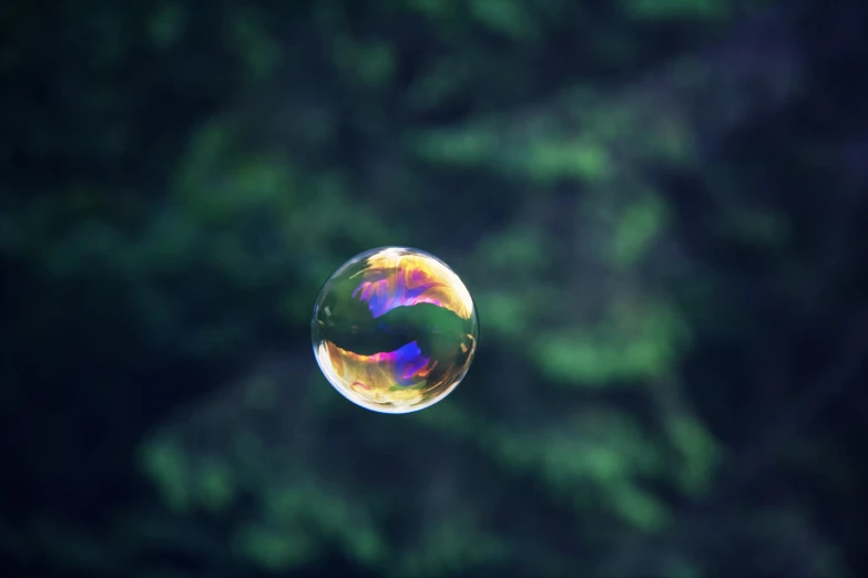 a rainbow colored bubble flying into the sky