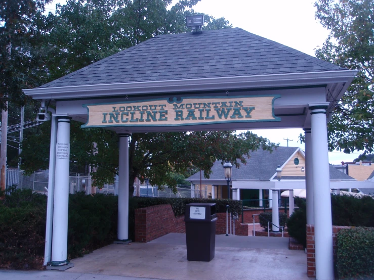 a covered walkway with a blue roof and a large sign above it