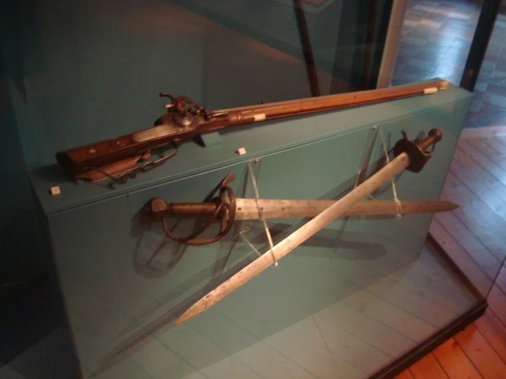 old weapons displayed on glass display case