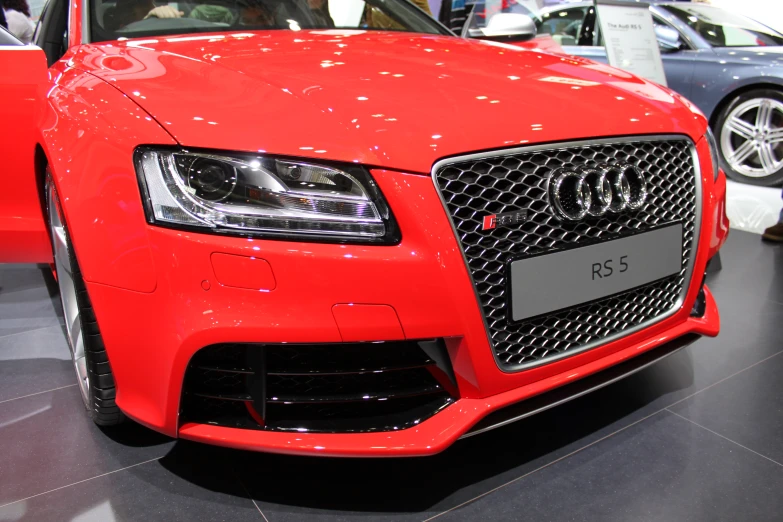 a red audi car is parked on the floor