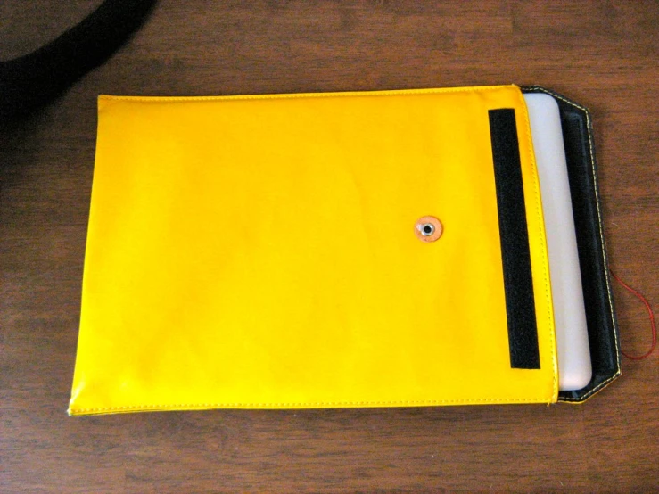 yellow folder with a black strip attached to the cover