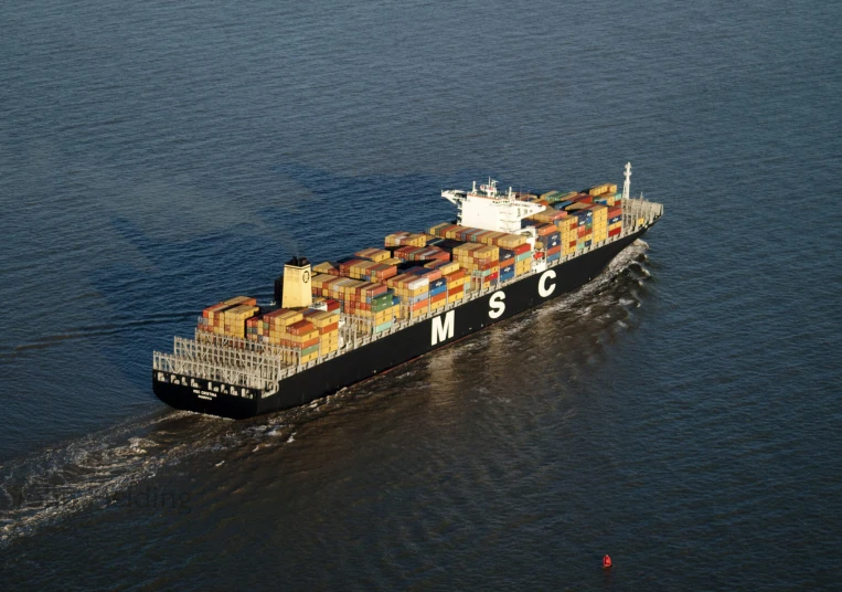 a big boat filled with lots of containers sailing in the water