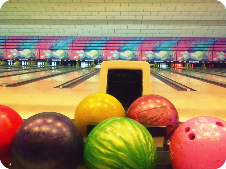 an array of colorful bowling balls on a bowling alley