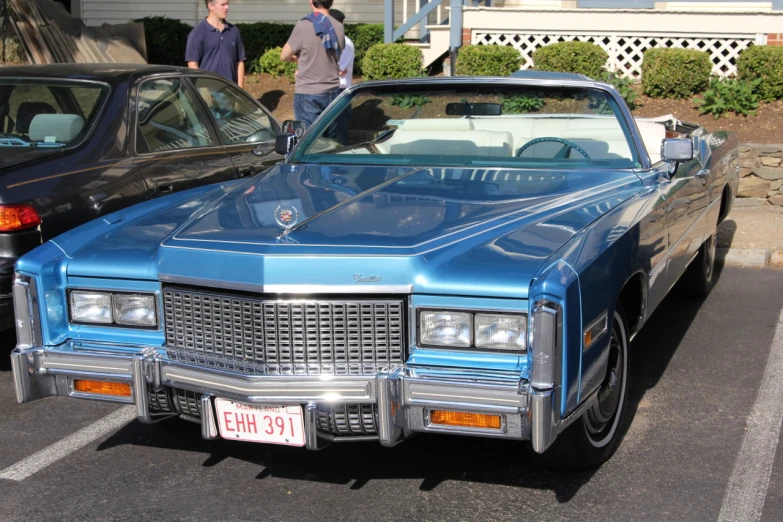 two old classic automobiles parked in a parking lot