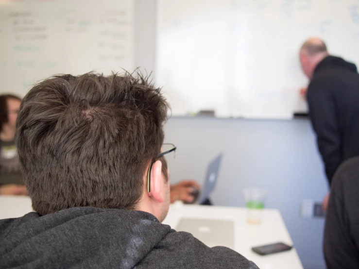 man wearing glasses while listening to someone on his cellphone