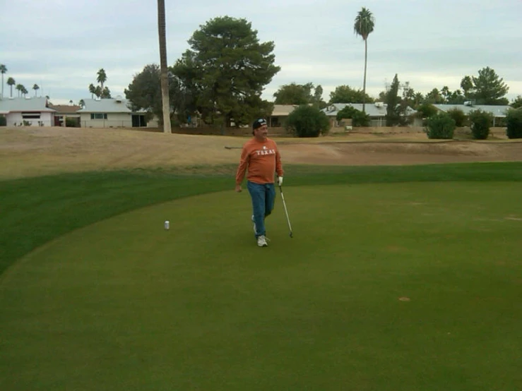 man walking on the green with a golf ball in his hand