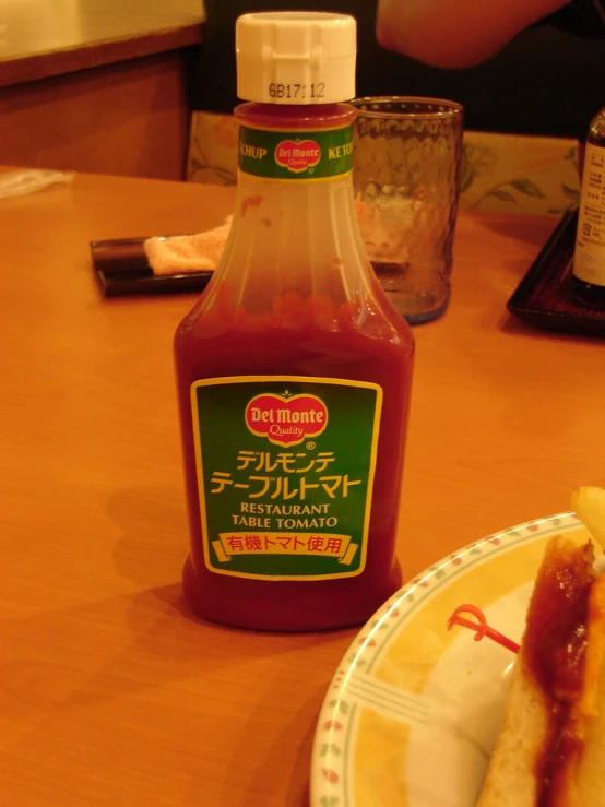 a bottle of ketchup sitting next to a plate