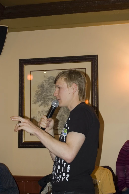 a man talking on a microphone while holding a microphone