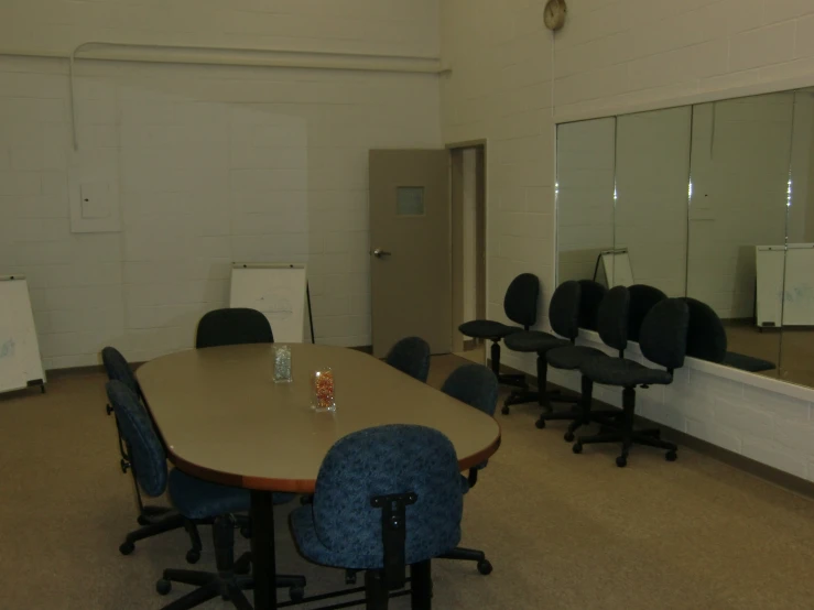 a meeting room with several chairs and mirrors