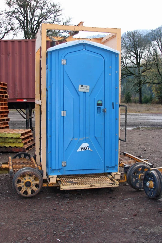 an outhouse is parked on a trailer in a lot