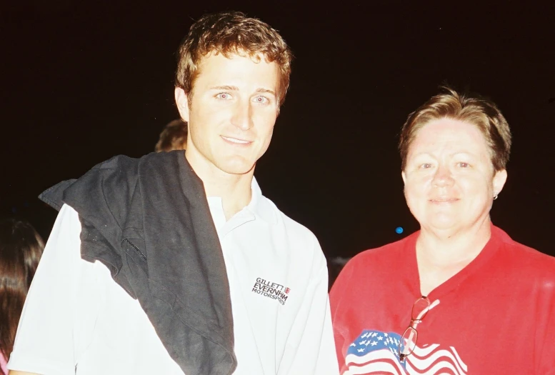 two people are standing together smiling for the camera