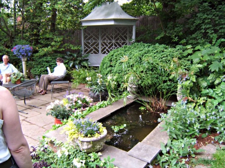 a couple are sitting in the garden with many flowers