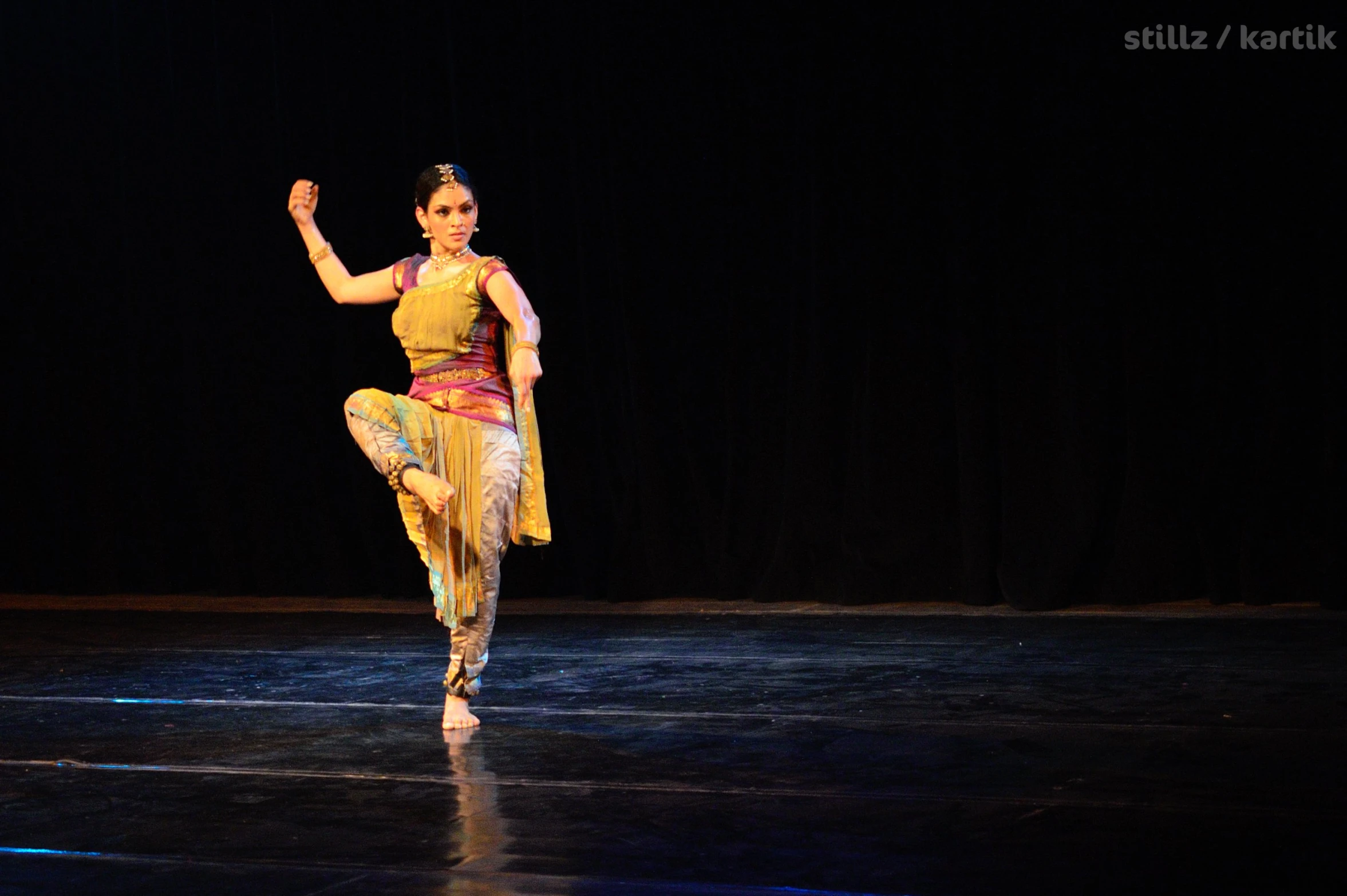 a woman dancing on a stage, with one leg up
