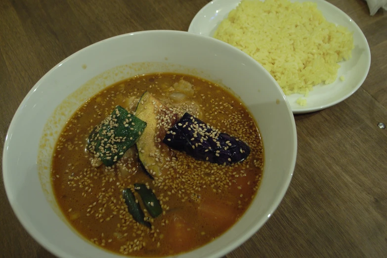 bowl full of soup and plate of food on the table