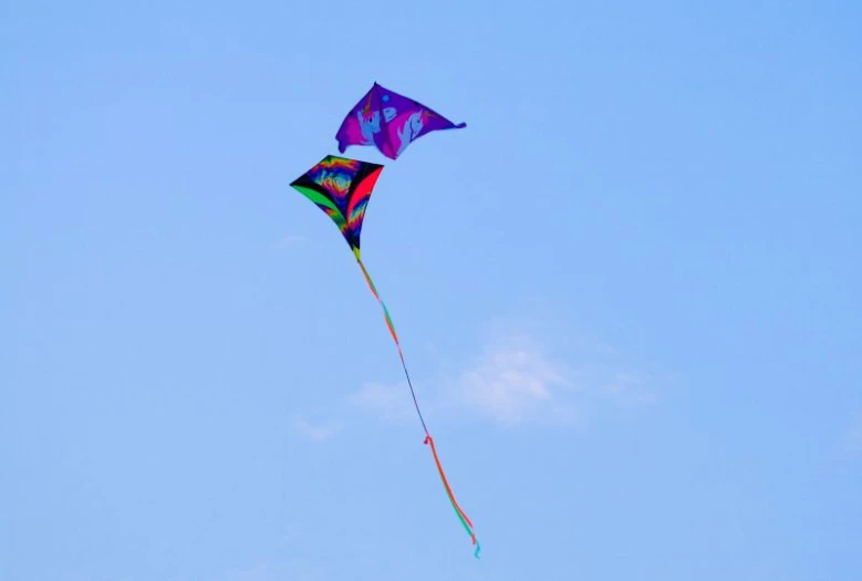 a colorful kite in a blue sky is flying