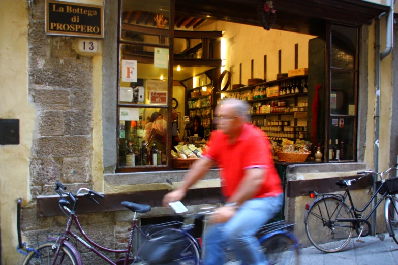 a man riding a bicycle past a store