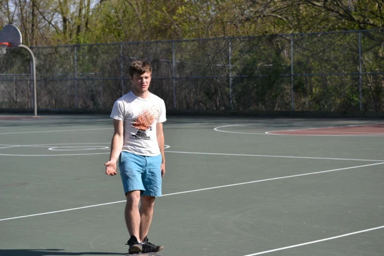 a man standing in front of an empty basketball court