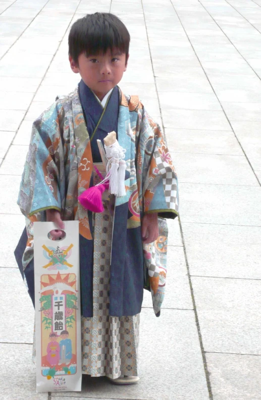 a boy wearing kimono with a skate board