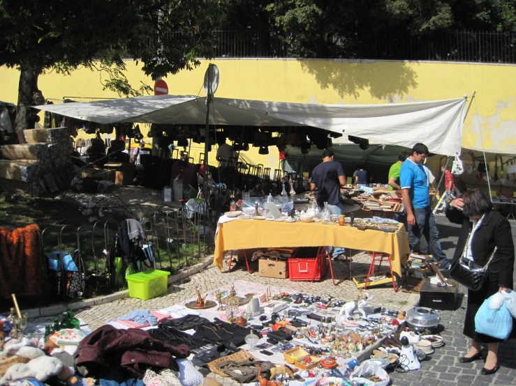 a group of people standing at a table with many items on it