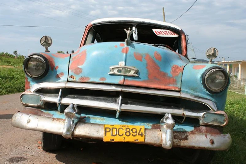 an old car parked on the side of a road