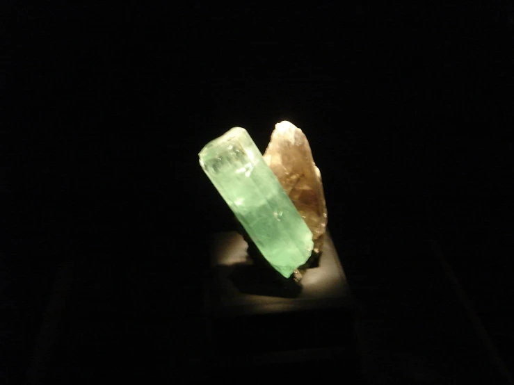 a small crystal object is lit up in the dark