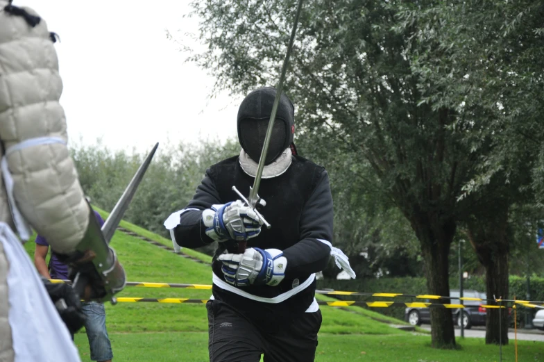 the person wearing a face mask is holding two swords