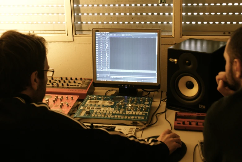 a man in the foreground is looking at a computer