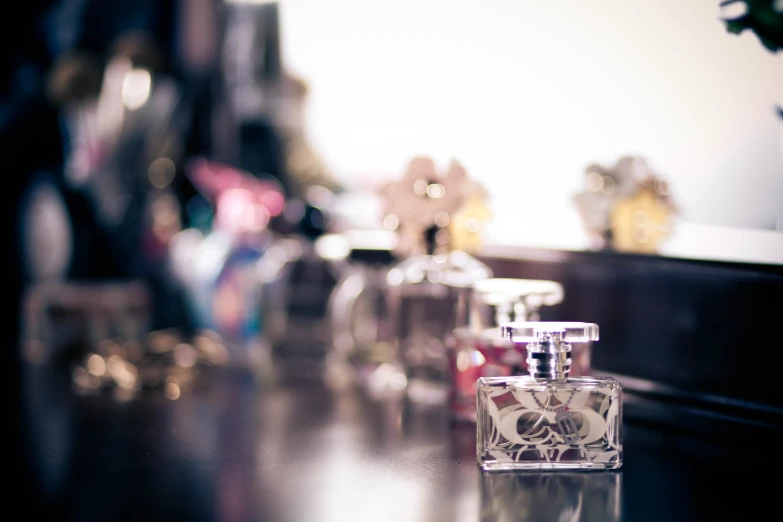 an empty perfume bottle sits next to a bunch of bottles