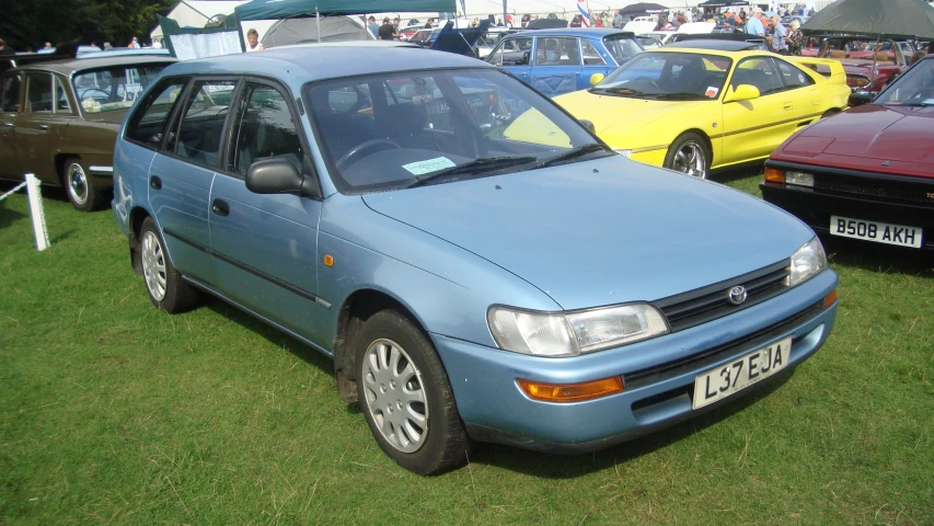 a blue sedan is parked in a line