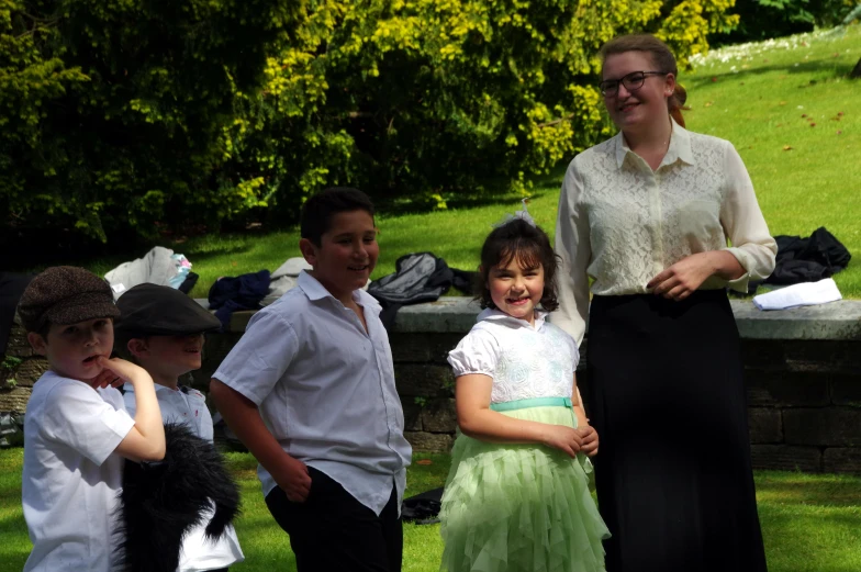 a woman standing in front of four children